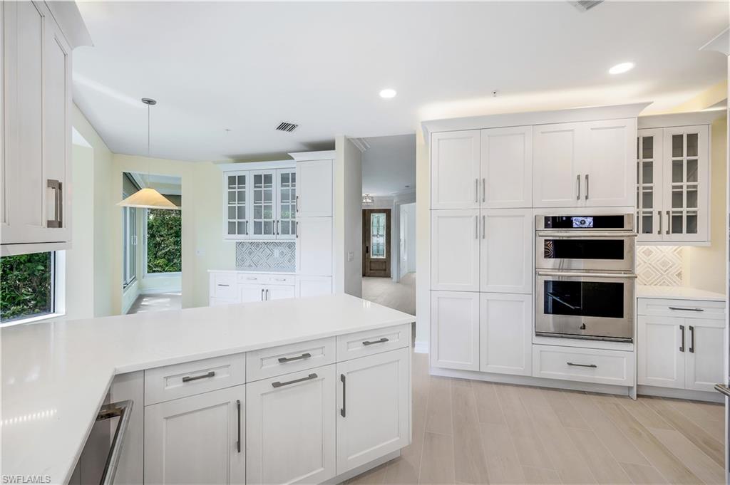 217 Colonade Circle Naples, FL 34103 - Photo 10 of 40 a kitchen with stainless steel appliances white cabinets and a refrigerator