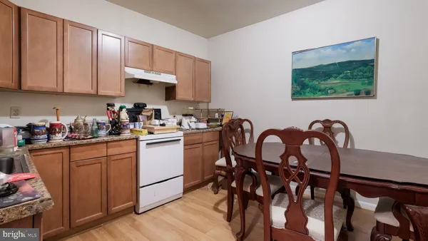 a kitchen with stainless steel appliances granite countertop a stove top oven a sink with dining table and chairs
