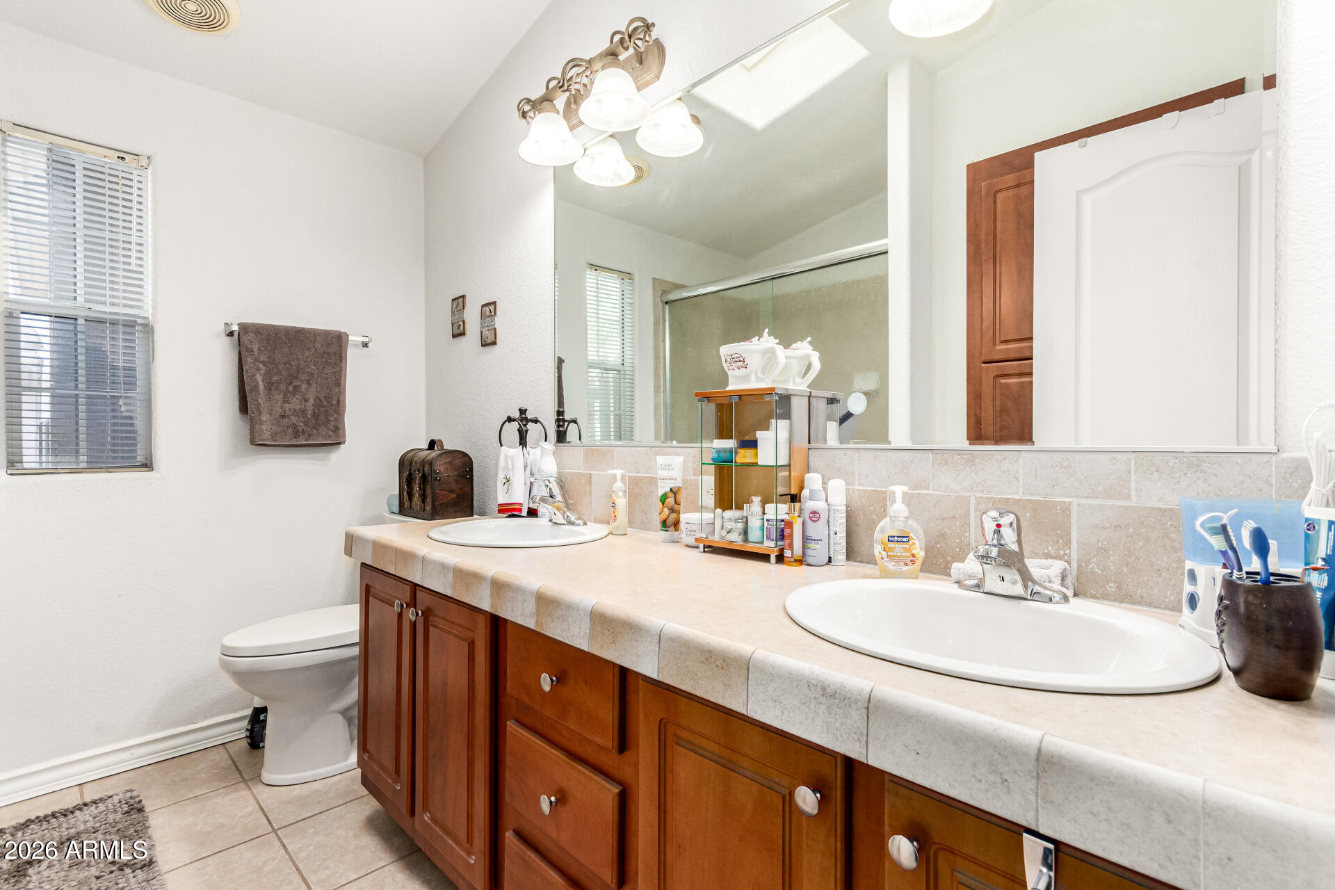 201 South Greenfield Road, Unit 90 Mesa, AZ 85206 - Photo 19 of 32 a bathroom with a granite countertop sink a toilet and a mirror