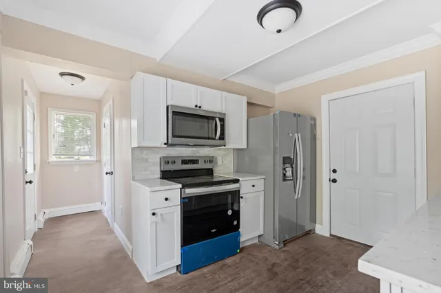 a kitchen with stainless steel appliances granite countertop a refrigerator and a stove top oven