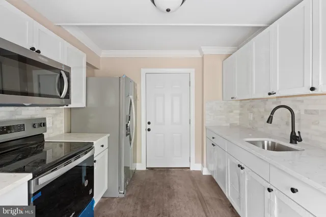a kitchen with stainless steel appliances granite countertop a sink and a stove top oven