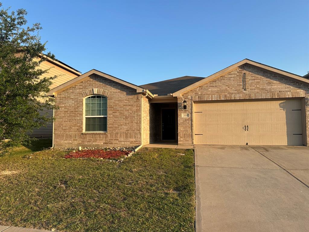 1818 Clegg Street Howe, TX 75459 - Photo 1 of 34 Brick facade residence featuring an arched window, a two-car garage with decorative hardware, a concrete driveway, and a front yard with a landscaped bed