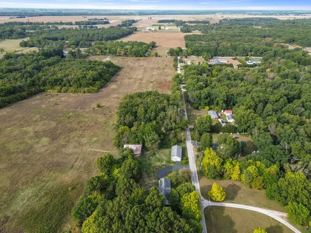 an aerial view of residential houses with outdoor space and trees