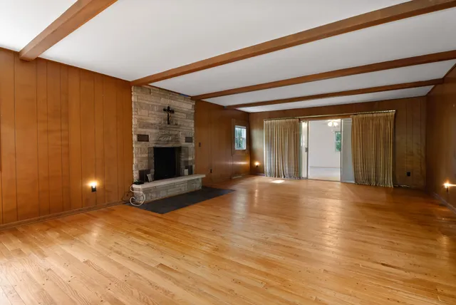 a view of empty room with wooden floor and fireplace