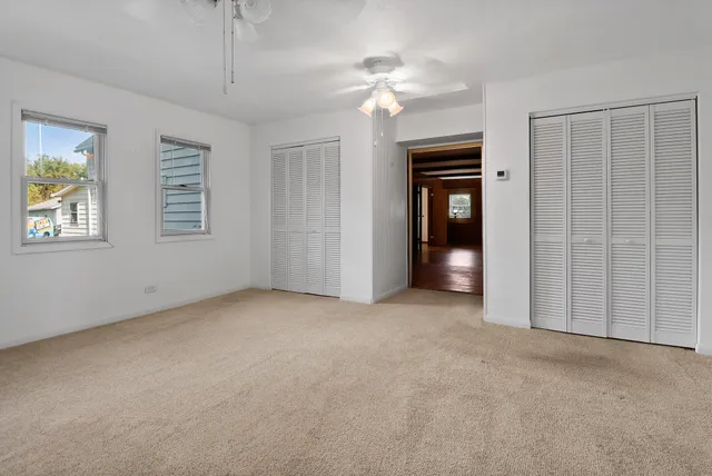 an empty room with windows and closet