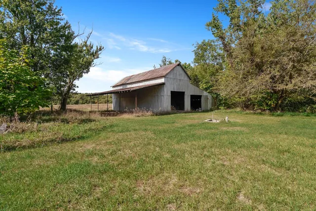 a front view of a house with yard and tree