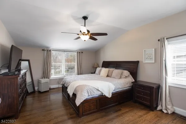 a bedroom with a bed a window and flat screen tv
