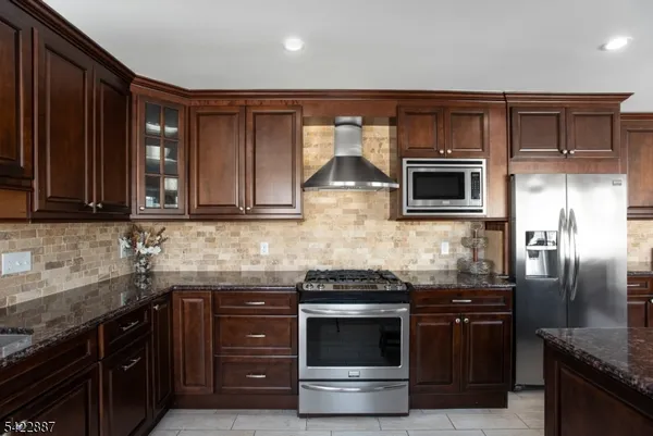 a kitchen with stainless steel appliances granite countertop a stove microwave and refrigerator