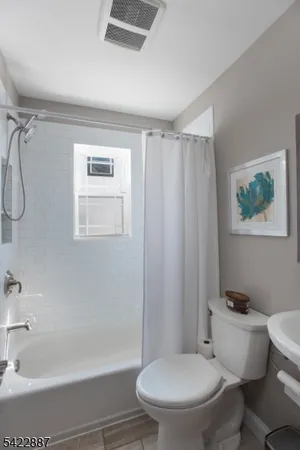 a white toilet sitting next to a bath tub