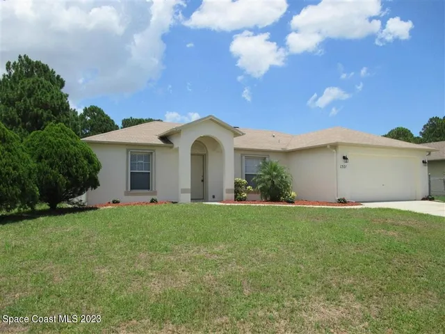 a view of a house with a yard and garage