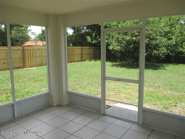 an empty room with a chandelier fan