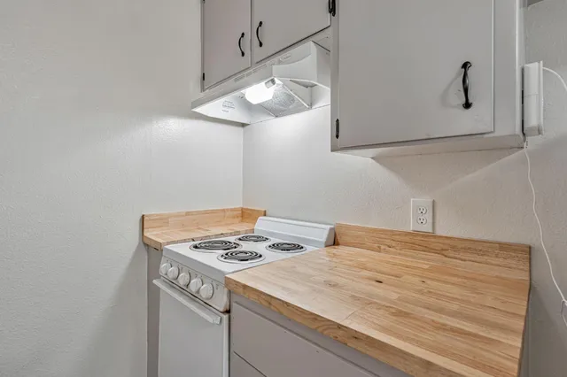 a kitchen with a table and white cabinets