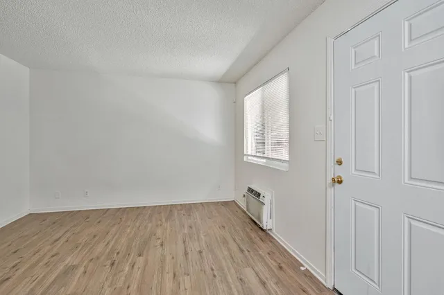 a view of a room with wooden floor and white walls
