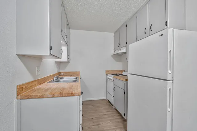 a white refrigerator freezer sitting inside of a kitchen