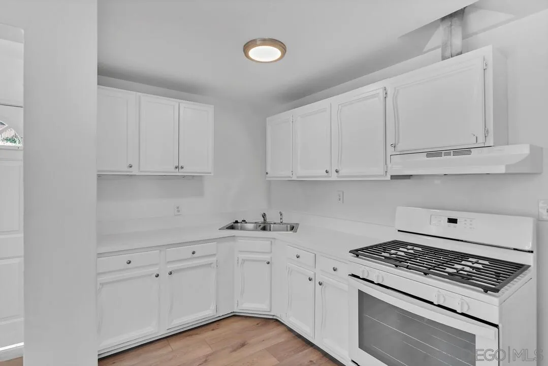 7901 Hillside Drive La Mesa, CA 91942 - Photo 15 of 52 a kitchen with white cabinets and appliances