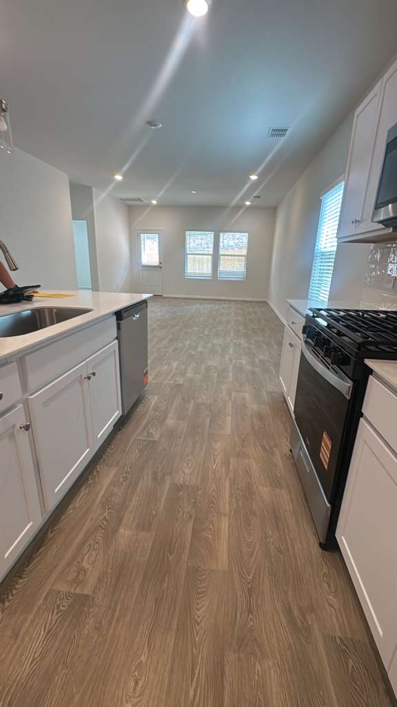 174 Balmorhea Street Kyle, TX 78640 - Photo 5 of 29 Bright, open-concept kitchen and living area with contemporary flooring and abundant natural light.