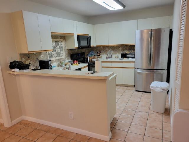 1008 Ocean Dunes Circle Jupiter, FL 33477 - Photo 9 of 19 a kitchen with a sink a refrigerator a stove a microwave and cabinets