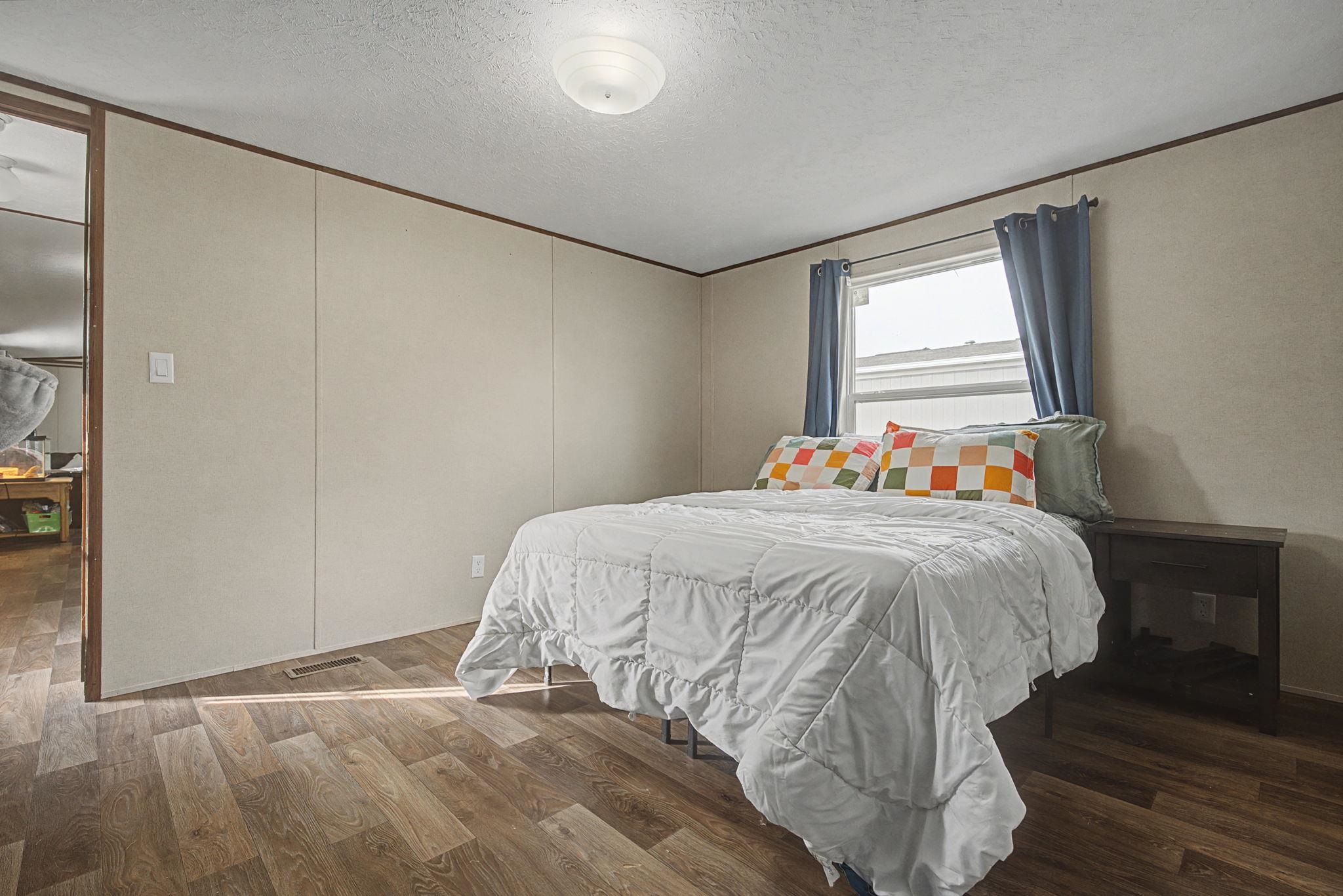 269 Clements Way Fruita, CO 81521 - Photo 18 of 20 a bed sitting in a bedroom next to a window and a mirror