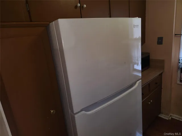 a white refrigerator freezer and a stove sitting inside of a kitchen