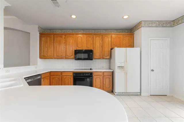 a kitchen with stainless steel appliances granite countertop a refrigerator a stove top oven a sink and dishwasher