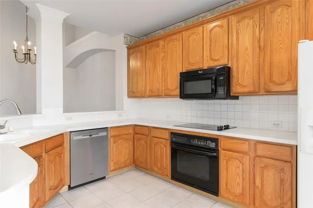 a kitchen with stainless steel appliances granite countertop white cabinets sink and a granite counter top