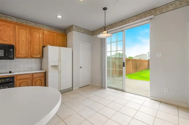 a kitchen with a refrigerator a stove top oven a sink and a window