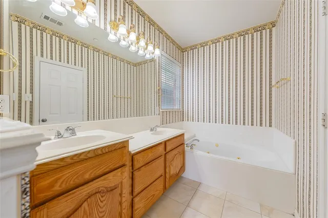 a spacious bathroom with a tub sink and mirror