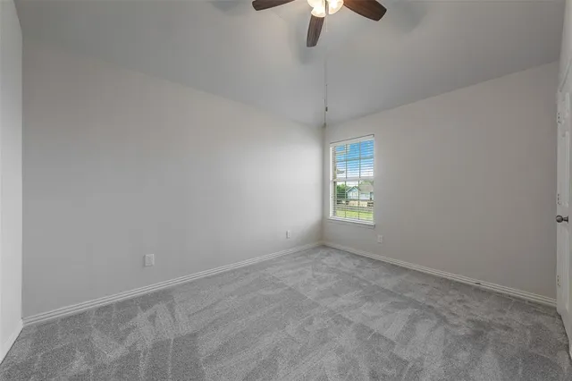 en empty room with windows and fan