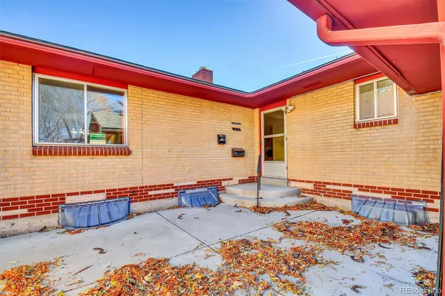 a backyard with a table and chairs and potted plants