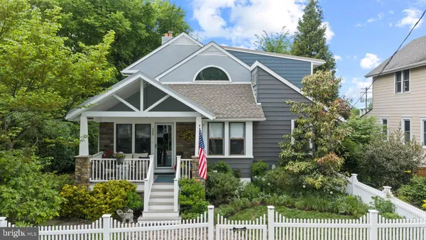 a front view of a house with a yard and potted plants