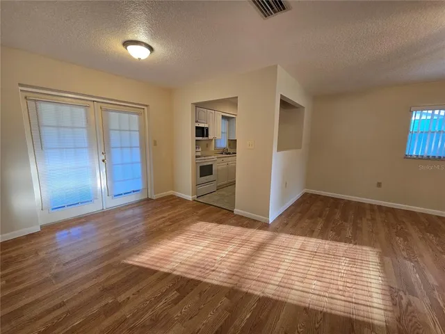 a view of empty room with wooden floor