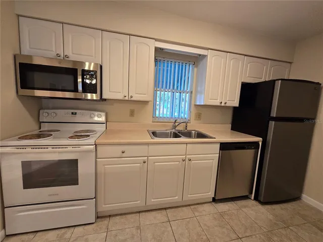 a kitchen with a sink stove and refrigerator