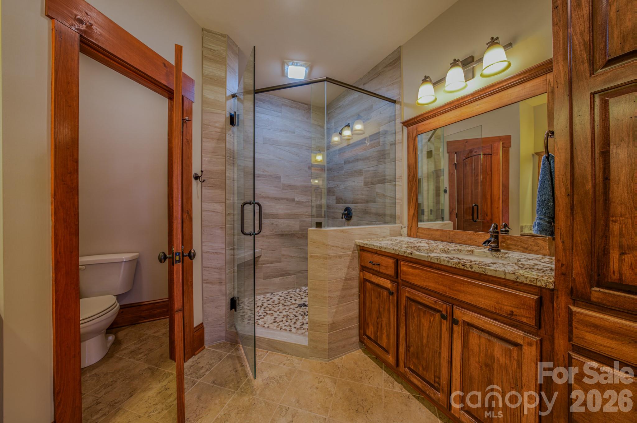4836 Stream Side Lane, Unit 18 Morganton, NC 28655 - Photo 15 of 46 a bathroom with a granite countertop sink mirror and a toilet