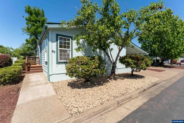 a front view of a house with a yard and potted plants