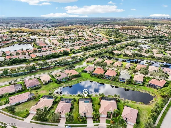 an aerial view of residential houses with outdoor space and trees