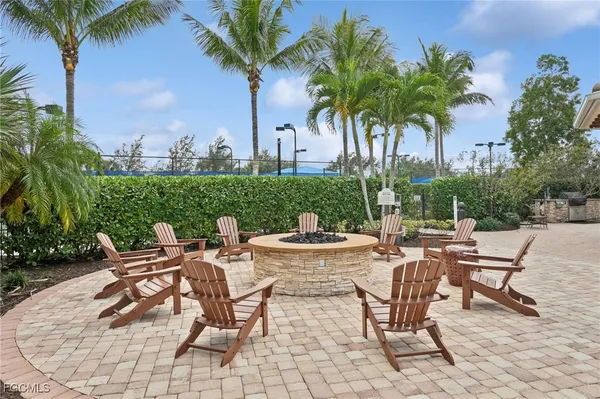 a view of a backyard with lawn chairs under an umbrella