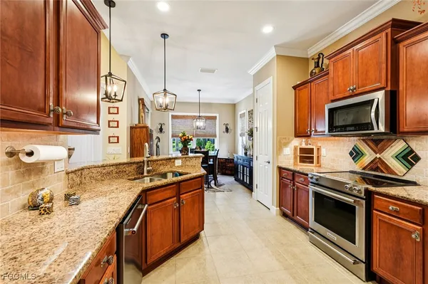 a kitchen with stainless steel appliances granite countertop a stove top oven a sink a refrigerator and cabinets
