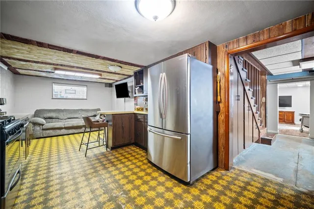 a kitchen with stainless steel appliances granite countertop a sink refrigerator and cabinets