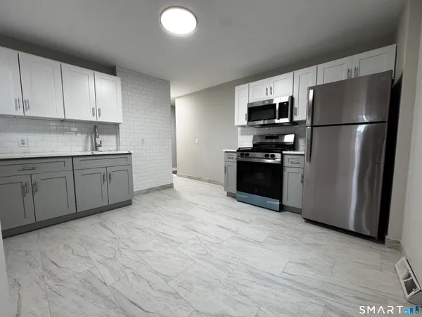 a kitchen with stainless steel appliances granite countertop a refrigerator sink and stove