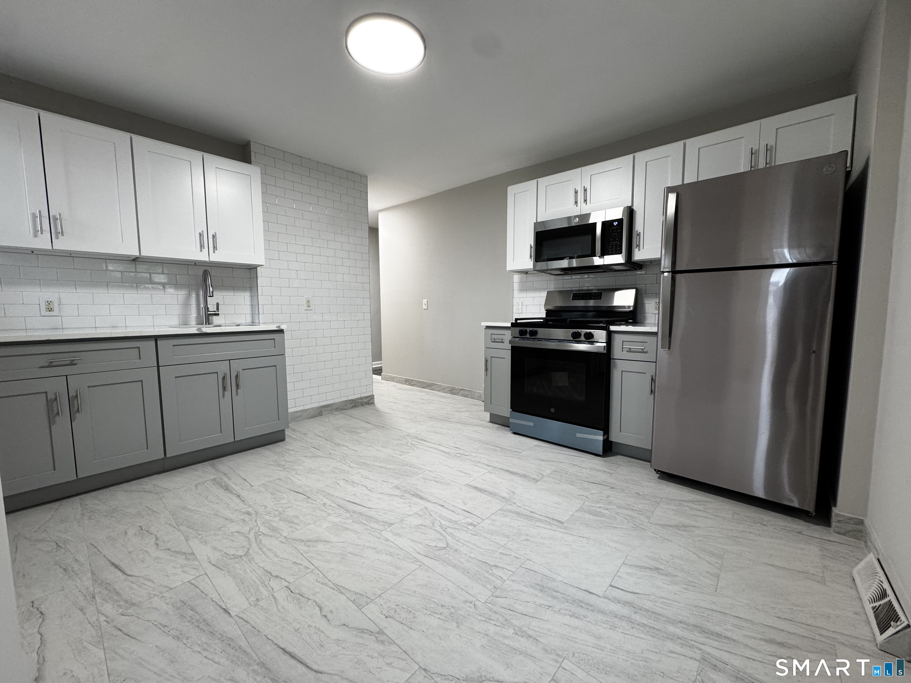 a kitchen with stainless steel appliances granite countertop a refrigerator sink and stove