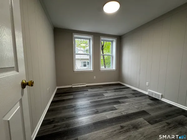 a view of empty room with wooden floor