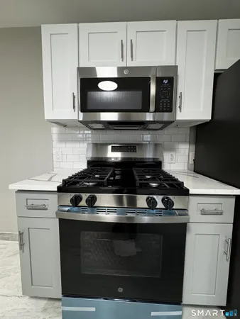 a stove top oven sitting inside of a kitchen