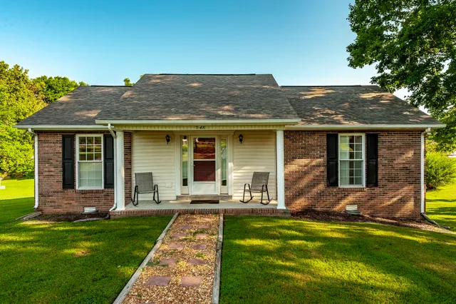 a view of a house with a yard and sitting area