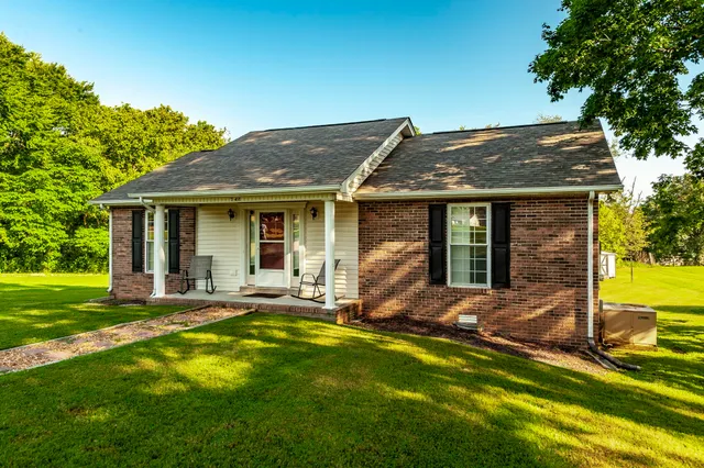 a view of a house with backyard sitting area and garden