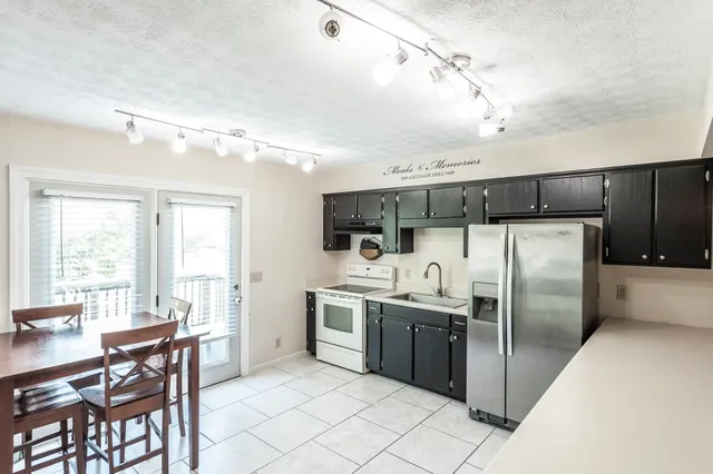 a kitchen with stainless steel appliances kitchen island granite countertop a refrigerator and a stove top oven