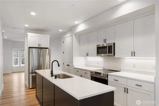 a kitchen that has a sink a stove and cabinets