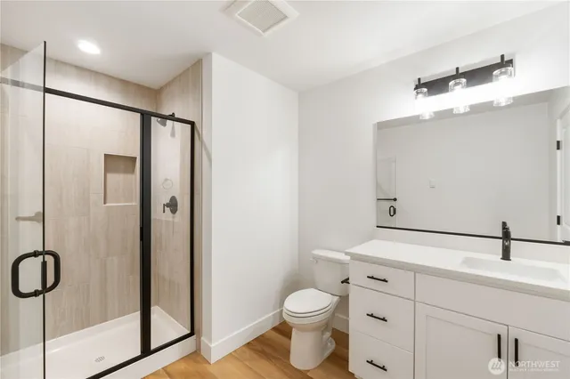 a bathroom with a shower sink mirror and toilet