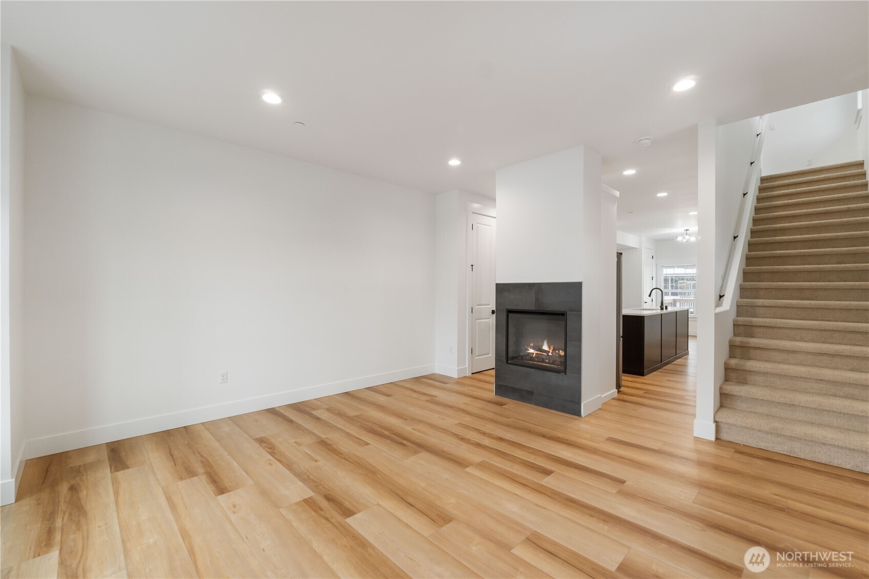 116 Orchard Avenue South, Unit ABCD Eatonville, WA 98328 - Photo 6 of 37 a view of an empty room with wooden floor and a fireplace