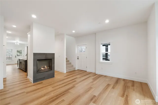 a view of empty room with wooden floor and fireplace