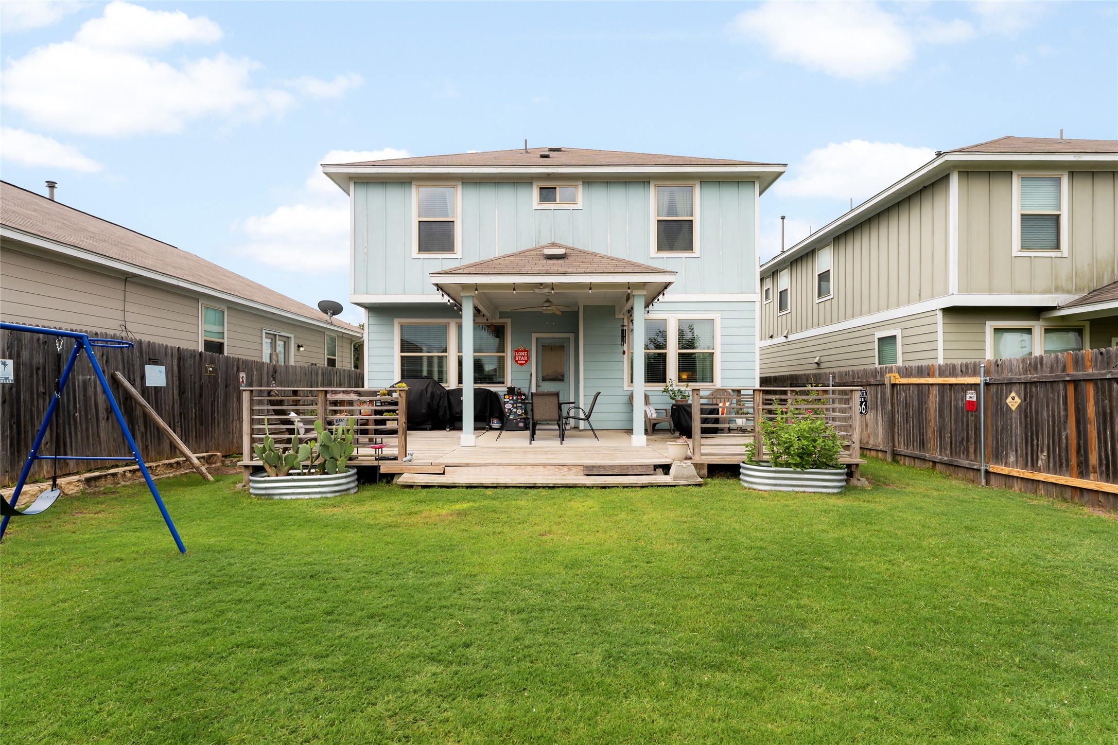 249 Wapiti Road Buda, TX 78610 - Photo 19 of 21 A vibrant backyard with a well-maintained lawn, a spacious deck, and a cozy covered patio area for outdoor enjoyment.